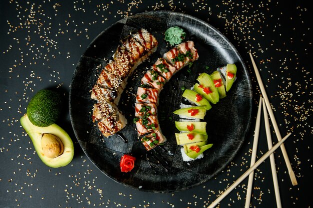 Sushi set with avocado, salmon, crab, sesame seeds, ginger and wasabi