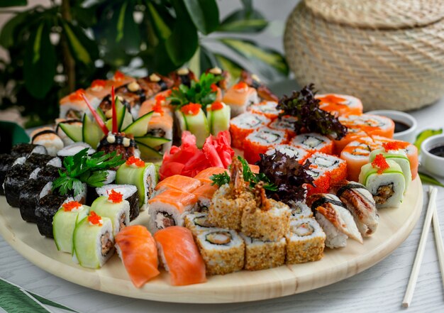 Sushi set with hot and cold rolls on wood platter