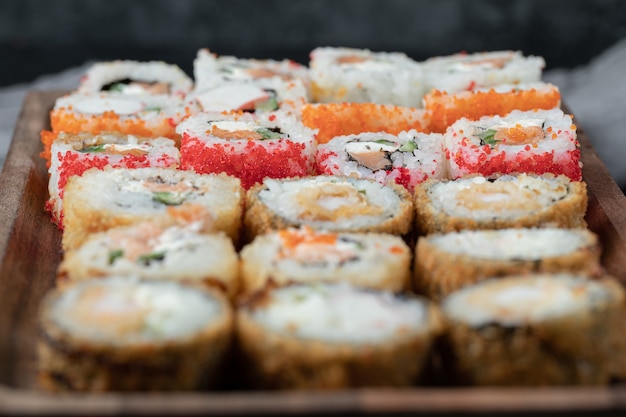 Sushi set on a wooden board with mixed ingredients.