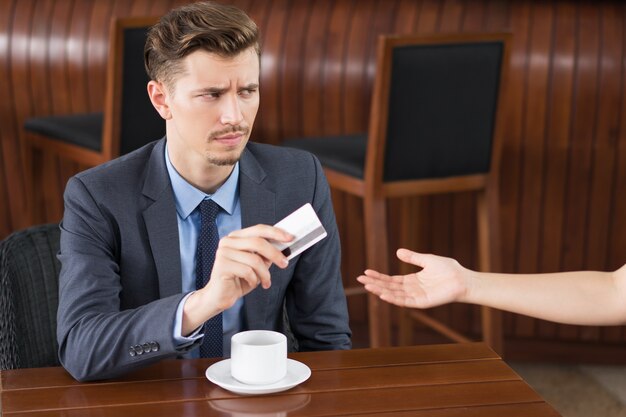 カフェウェイターにカードを与える不審なビジネスマン