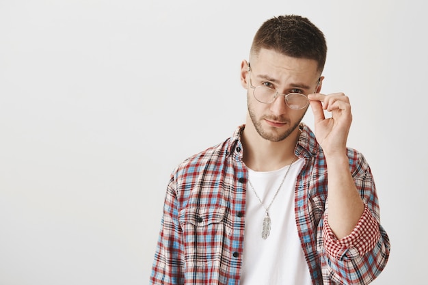 Suspicious young guy with glasses posing