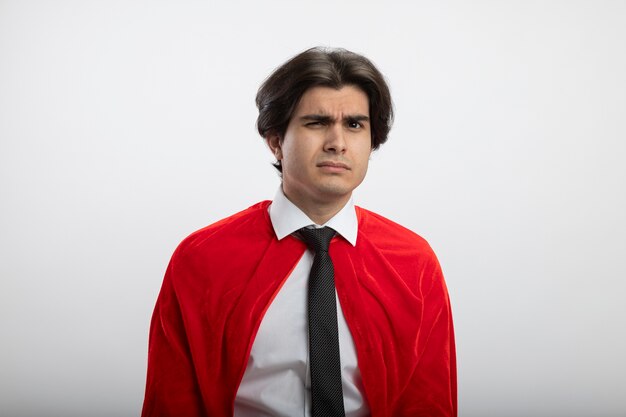 Suspicious young superhero guy looking at camera wearing tie isolated on white