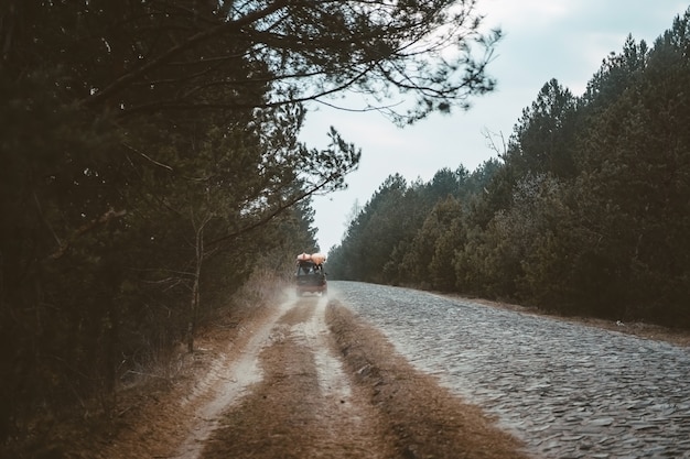 SUV rides on a dirt road at evening