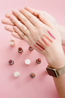 Swatch lipstick on the thin hand of a girl. swatches of different lipsticks.