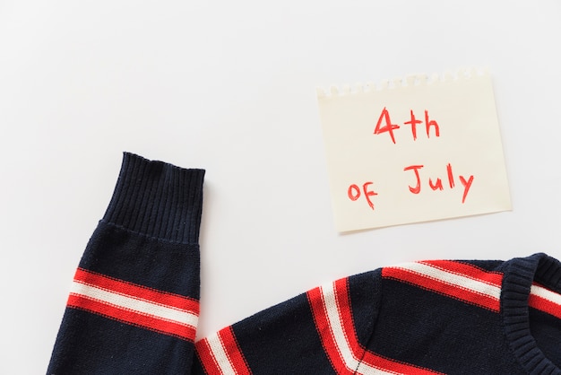 Sweater and sheet of paper with lettering 4th of July
