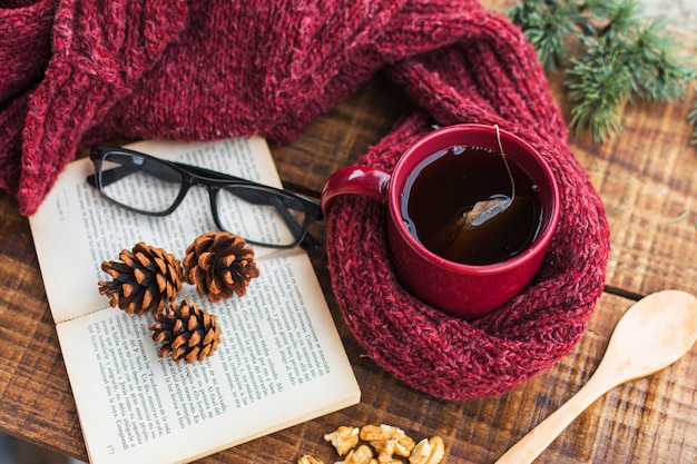 本と眼鏡の近くのセーターと紅茶