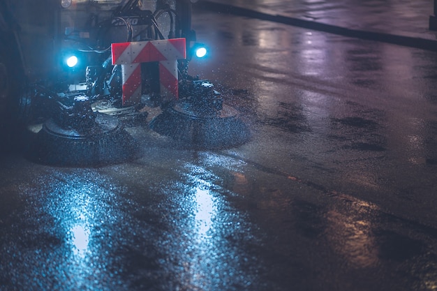 Free photo sweeping machines in rainy night