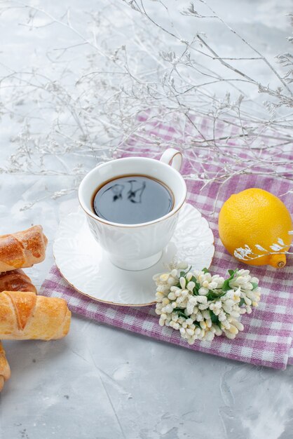 sweet bangles with filling along with coffee and lemon on light desk