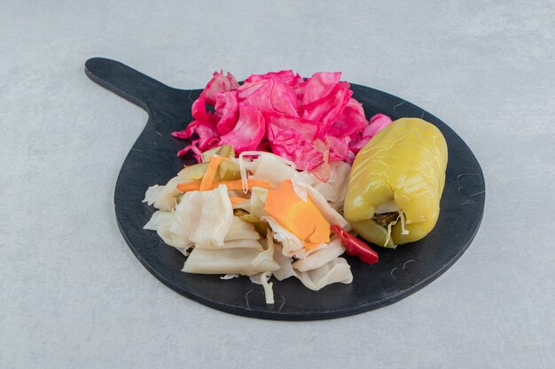 Sweet bell pepper and sauerkraut on the cutting board on the marble surface
