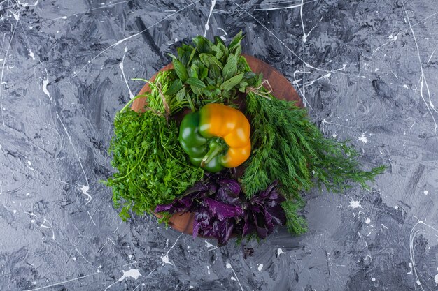 Sweet bell pepper with dill and basil in clay bowl.