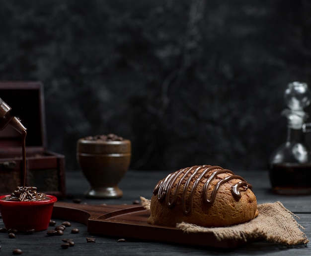 Сладкая булочка с шоколадным сиропом и шоколадным мороженым