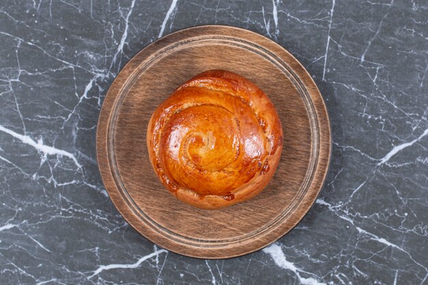 Sweet bun on the board, on the marble surface