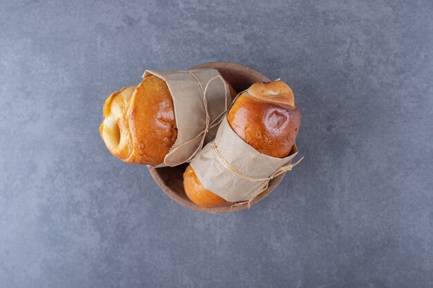 Sweet bun tied with a thread in a bowl, on the marble.