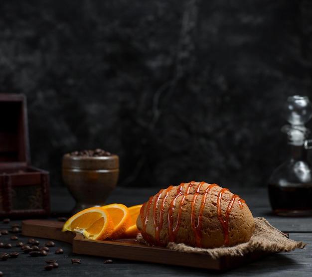 Sweet bun with cherry syrup and sliced orange fruit 