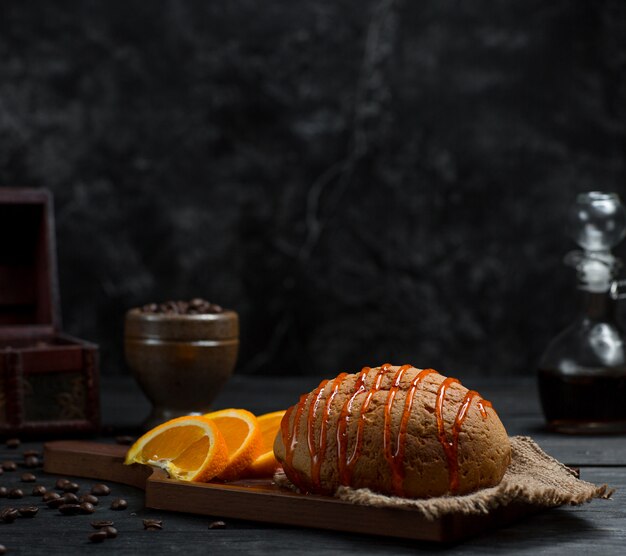 Sweet bun with cherry syrup and sliced orange fruit 