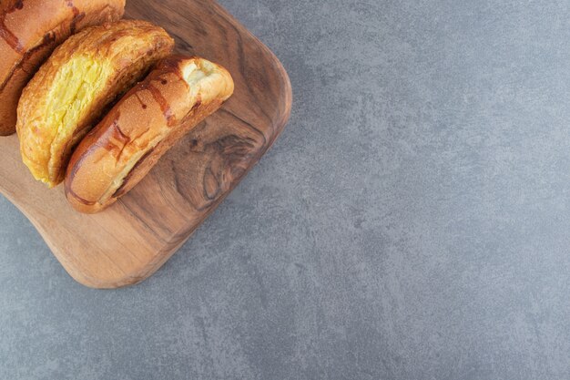 Sweet buns placed on wooden board. 