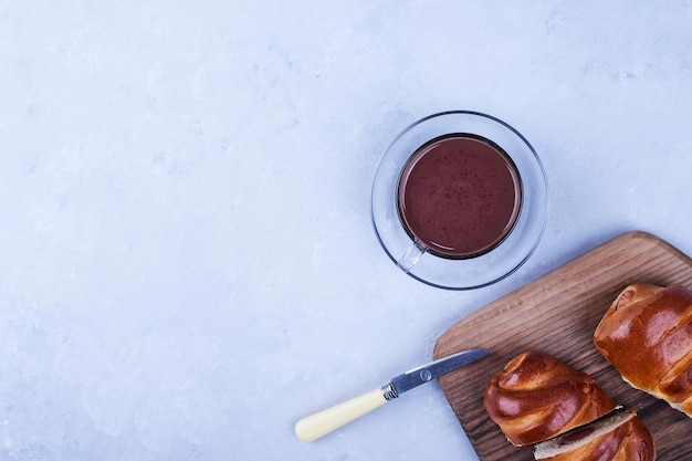 Free photo sweet buns on a wooden board with a cup of hot chocolate on the bottom corner