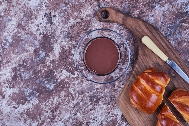 Free photo sweet buns on a wooden board with a cup of hot chocolate. high quality photo