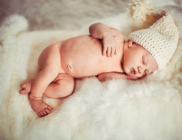 Sweet child sleeps on white fur