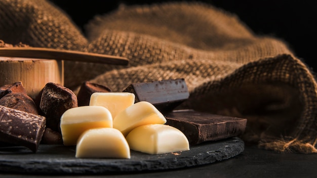 Foto gratuita disposizione del cioccolato zuccherato sul primo piano del bordo scuro