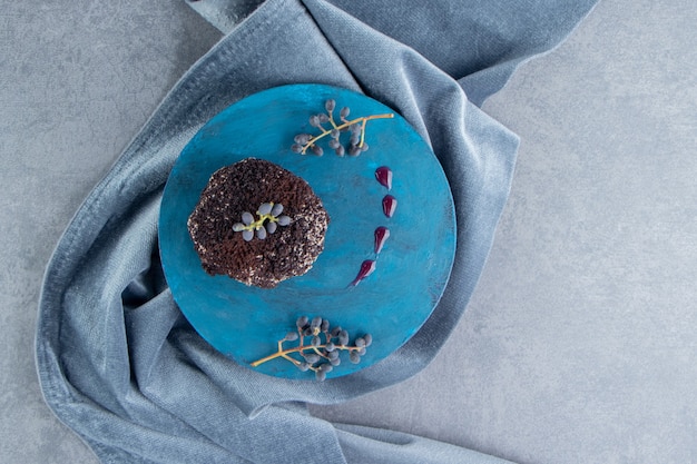 A sweet chocolate cupcake on a blue plate