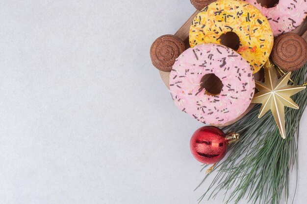 Сладкое рождественское печенье с шариками на белом столе.
