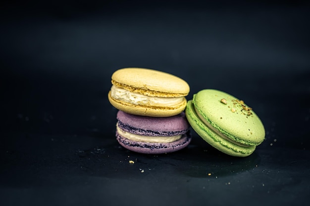 Free photo sweet and colorful french macaroons or macaron on black background