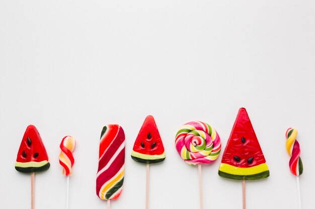 Sweet colorful lollipops on white table