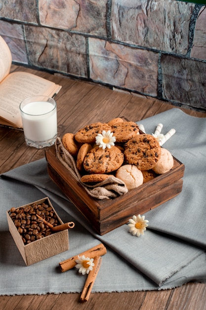 Foto gratuita scatola di biscotti dolce e un bicchiere di latte