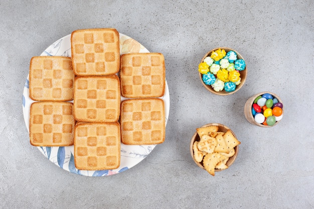 Biscotti dolci con caramelle colorate su una superficie grigia