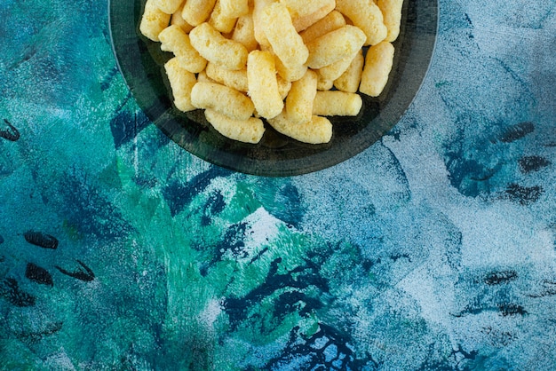 Sweet corn sticks on a glass plate plate , on the blue table.