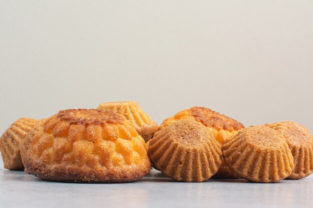 Sweet delicious cupcakes on white table.