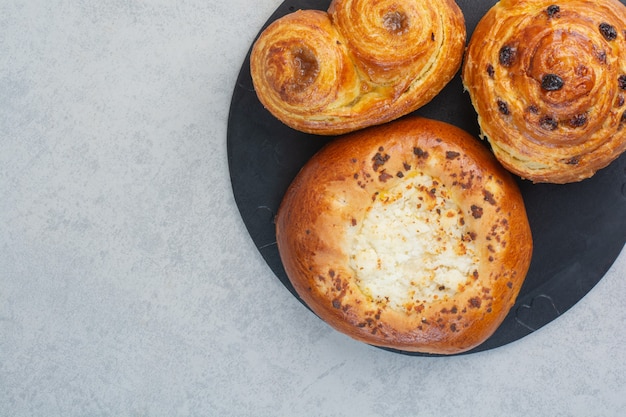 Sweet delicious pastries on dark board.