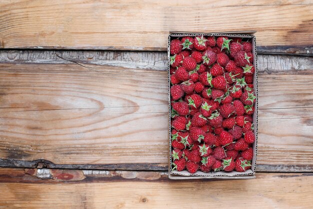 Sweet delicious raspberries in box on rustic ,top view