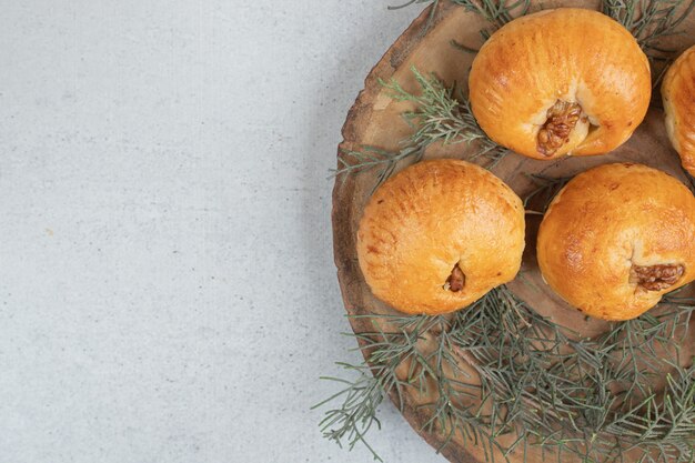 Sweet delicious round cookies with walnuts on wooden plate