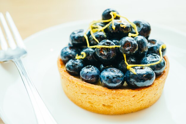 Sweet dessert with blueberry tart in white plate