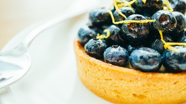 Foto gratuita dolce dolce con torta di mirtillo in piastra bianca