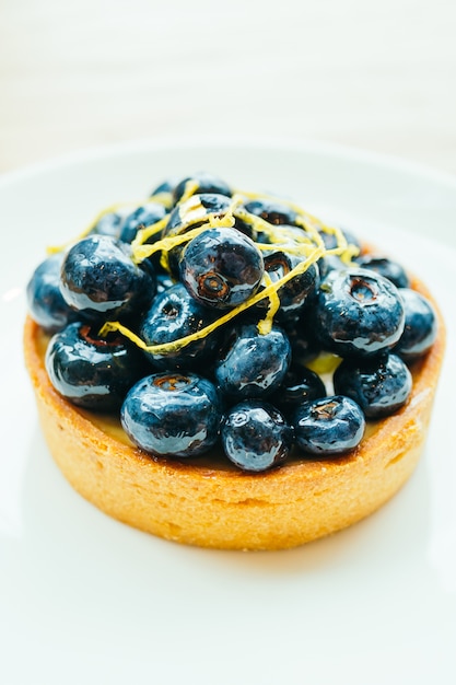 Sweet dessert with blueberry tart in white plate