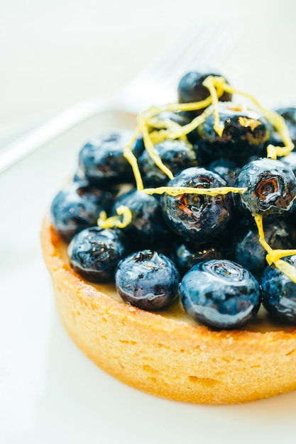 Foto gratuita dessert dolce con crostata ai mirtilli in zolla bianca