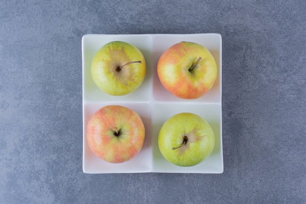 Plateon 대리석 테이블에 있는 달콤한 신선한 사과.