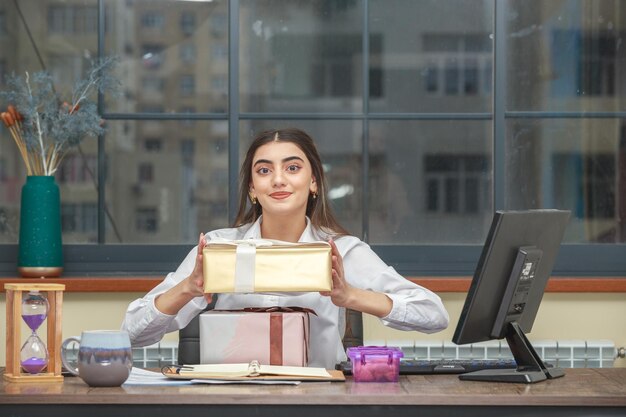 Sweet girl holding gift box and smiling