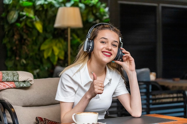 Free photo sweet girl wears headphones and gesture thumb up