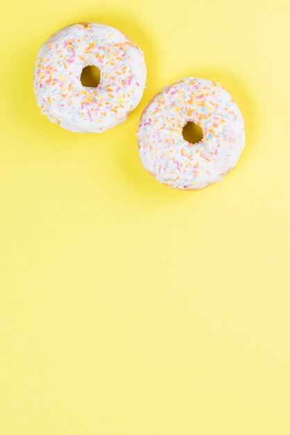 Sweet glazed donuts decorated with colorful sprinkles