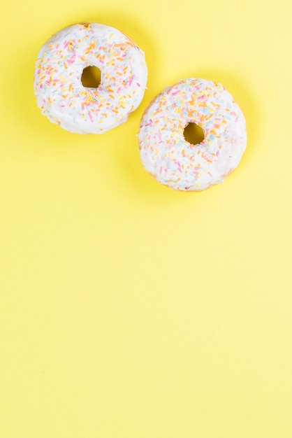Sweet glazed donuts decorated with colorful sprinkles