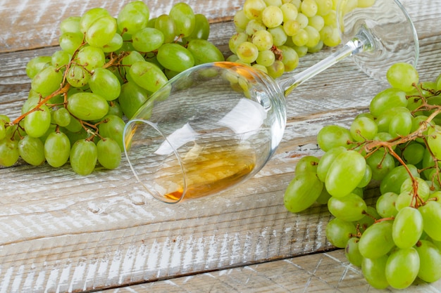 Sweet grapes with drink high angle view on a wooden background