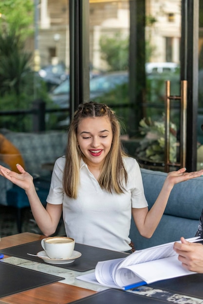 Sweet lady sitting at the restaurant and smiling