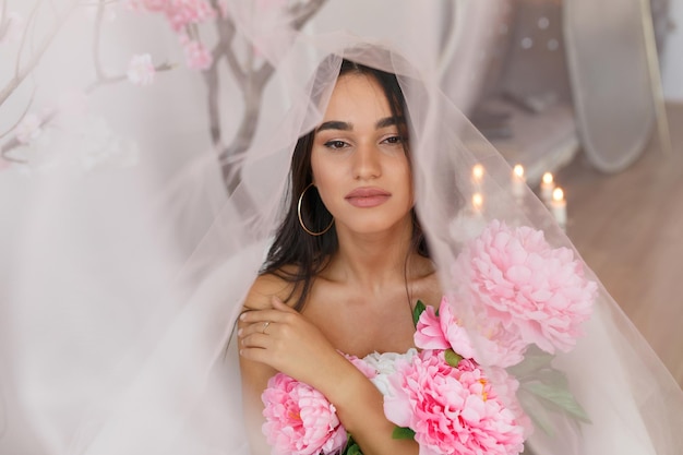 Sweet lady under the tulle holding bunch of flowers High quality photo