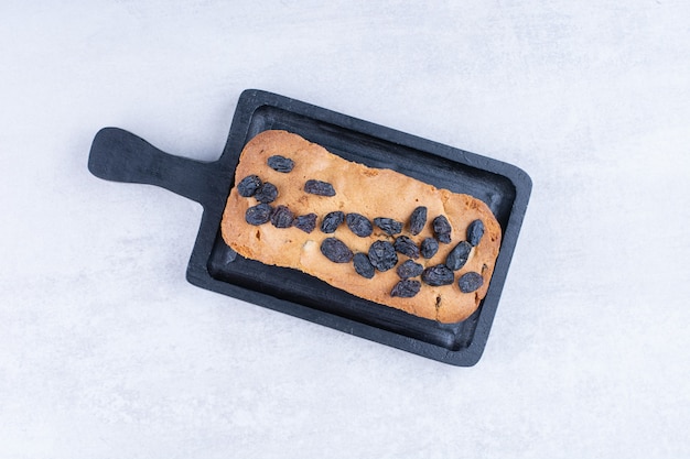 Sweet loaf with raisins on black board