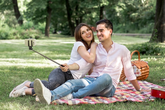 Free photo sweet lovers taking selfie at picnic