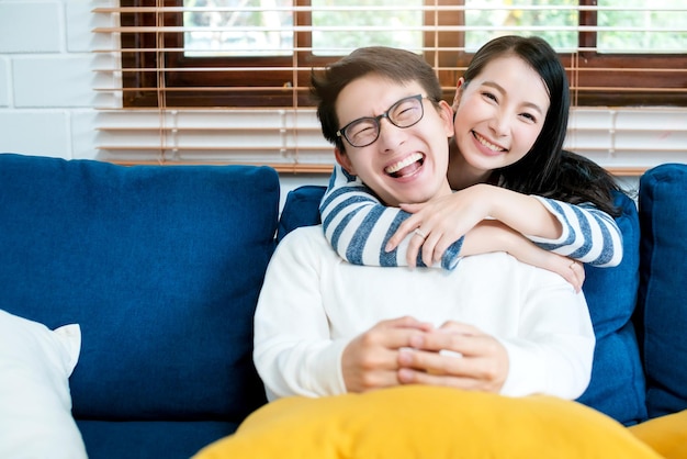 Sweet lovey asian family couple sit talk good conversation on sofa in living room house background